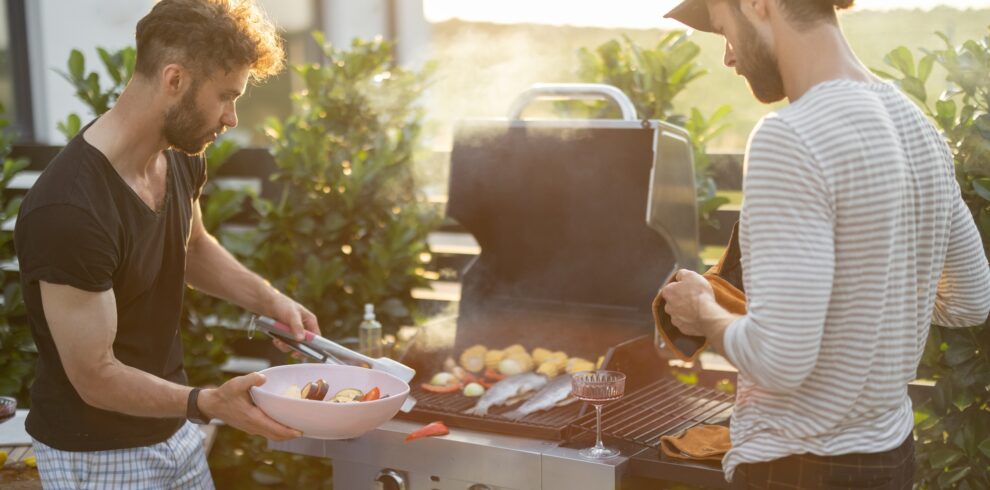 Guy grilling at backyard on a sunset