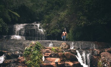 Topless man standing near waterfall in kodaikanal, india