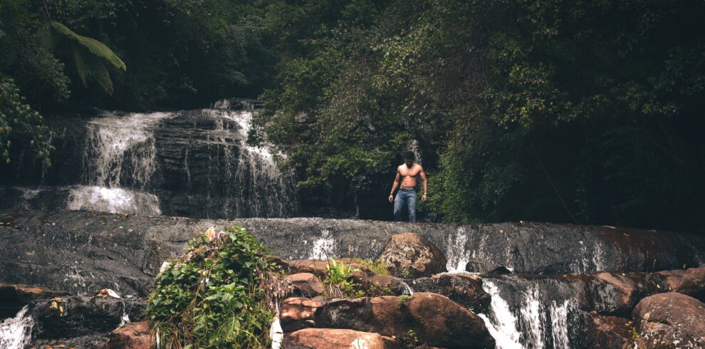 Topless man standing near waterfall in kodaikanal, india