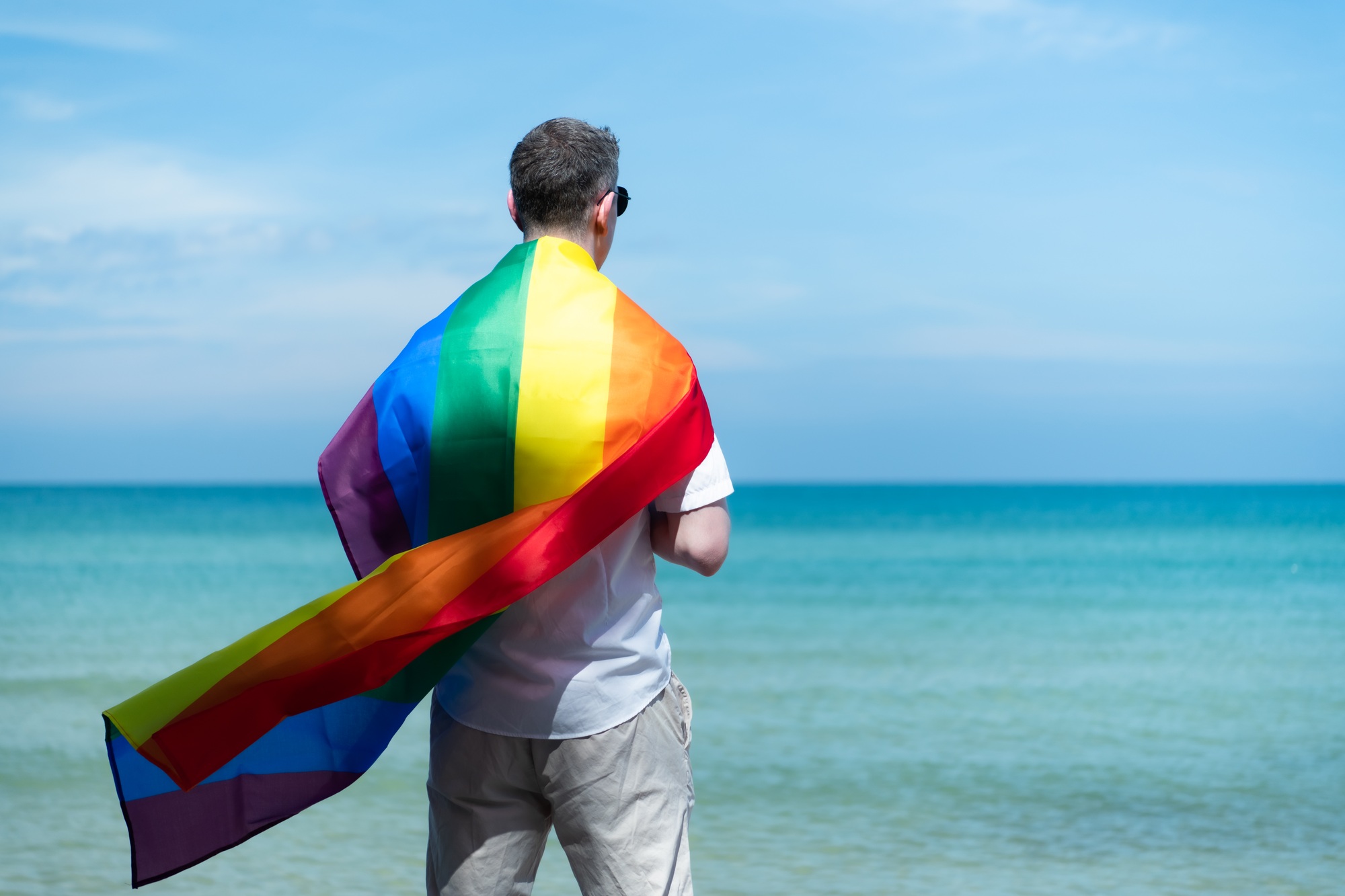 rainbow flags while standing on the beach