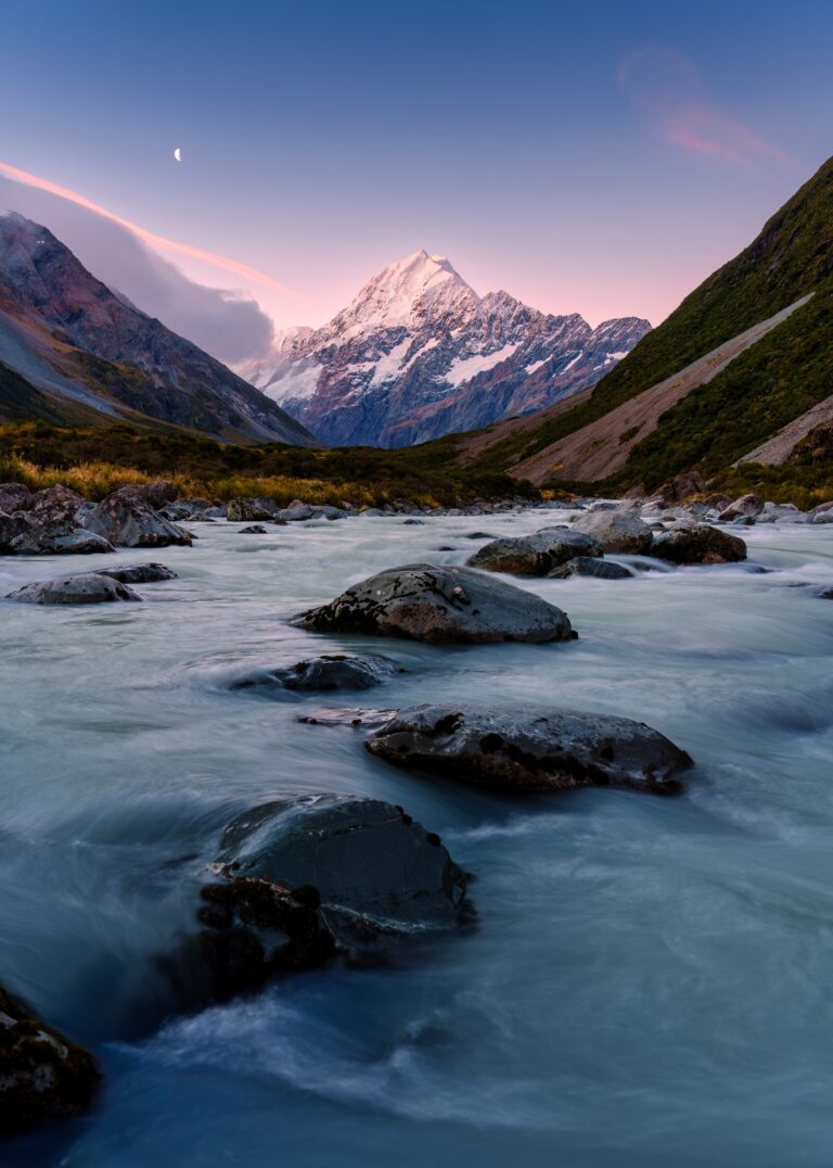 Sunset sky over Mount Cook with the moon and stream flowing in Hooker Valley Track at New Zealand