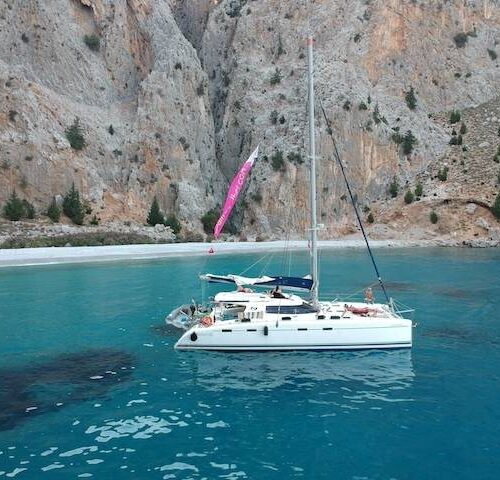 Clear turquoise water beneath the steep cliffs of St. George Bay on Symi